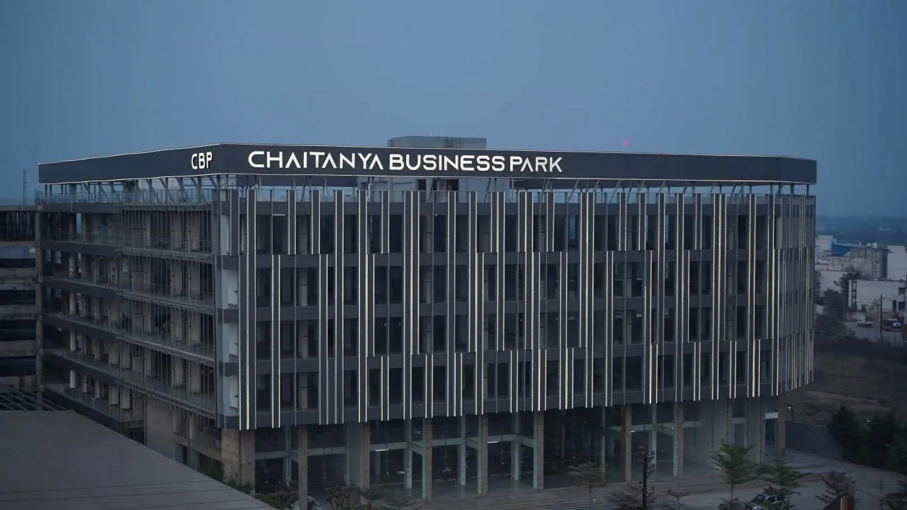 Chaitanya Business Park at dusk, with the illuminated rooftop signage