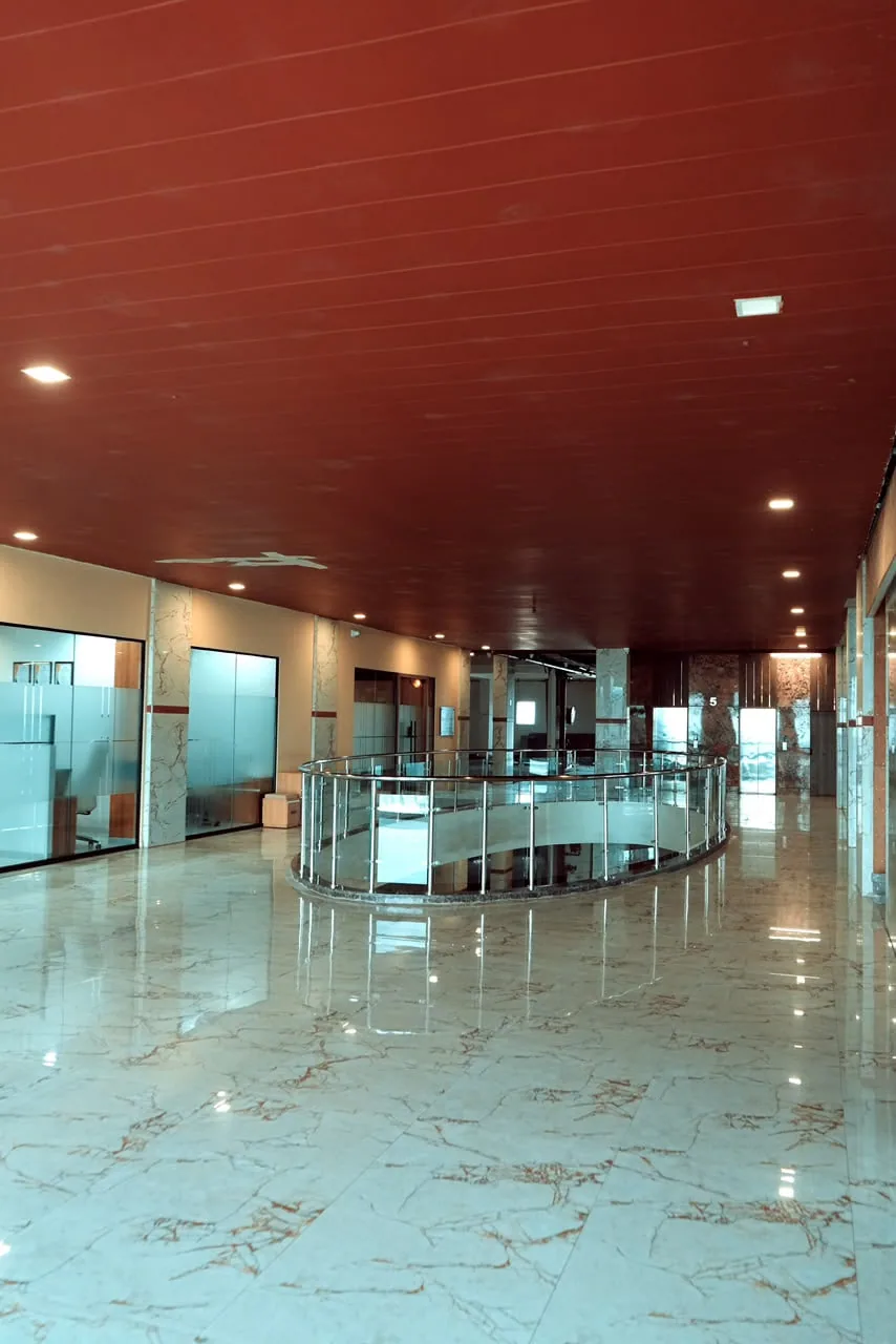A polished stone circulation spine under a timber ceiling