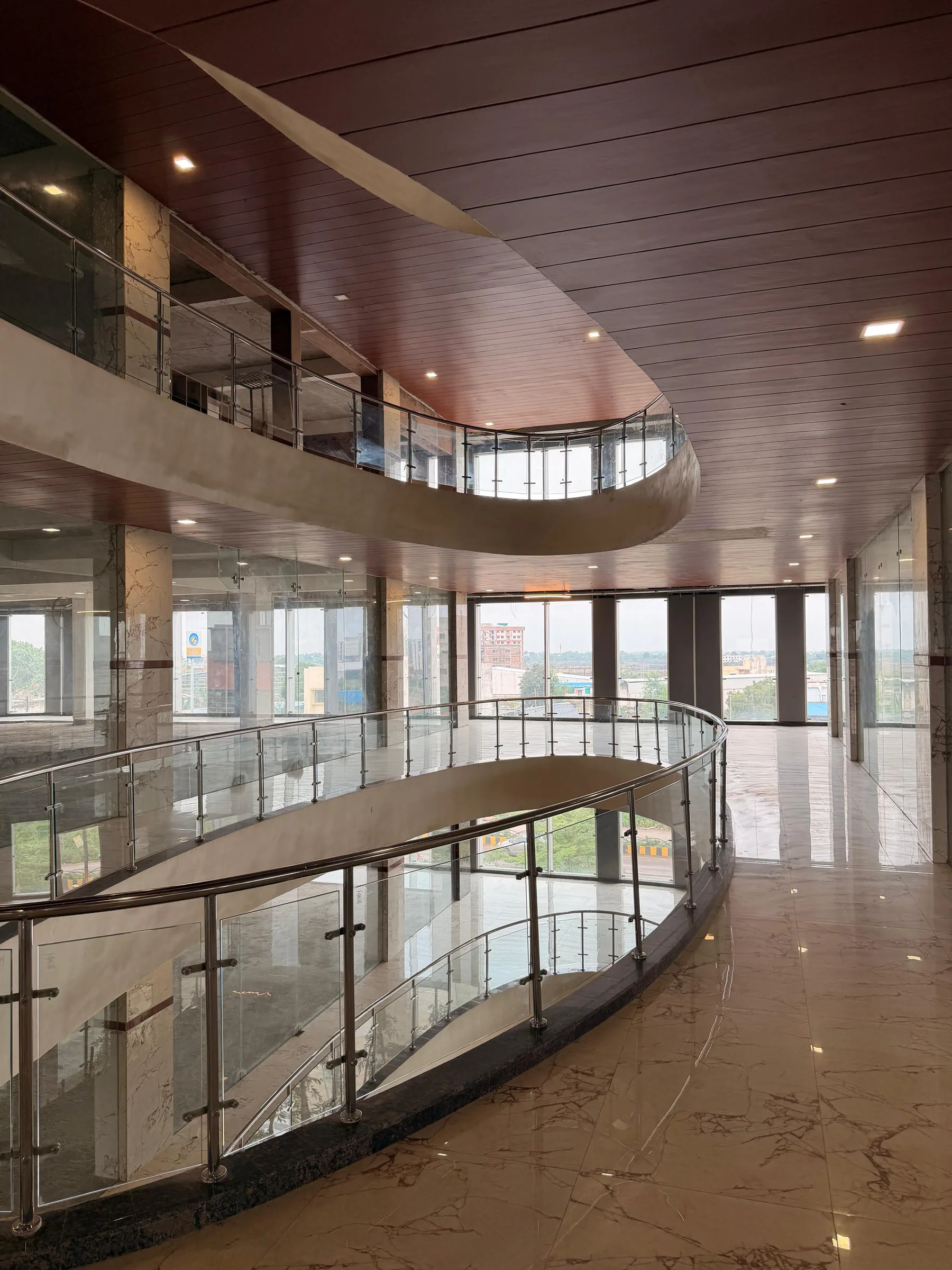 A curved corridor with glass balustrades overlooking the atrium