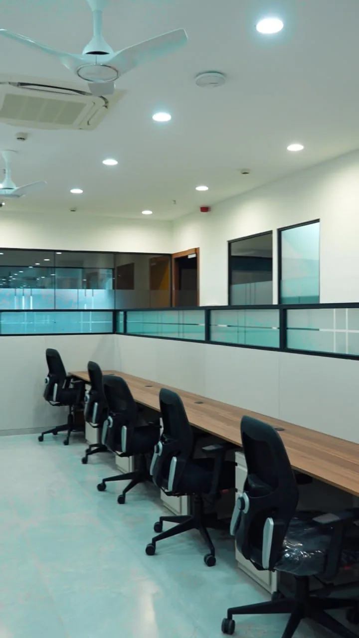 A fitted office with workstations along a glazed partition
